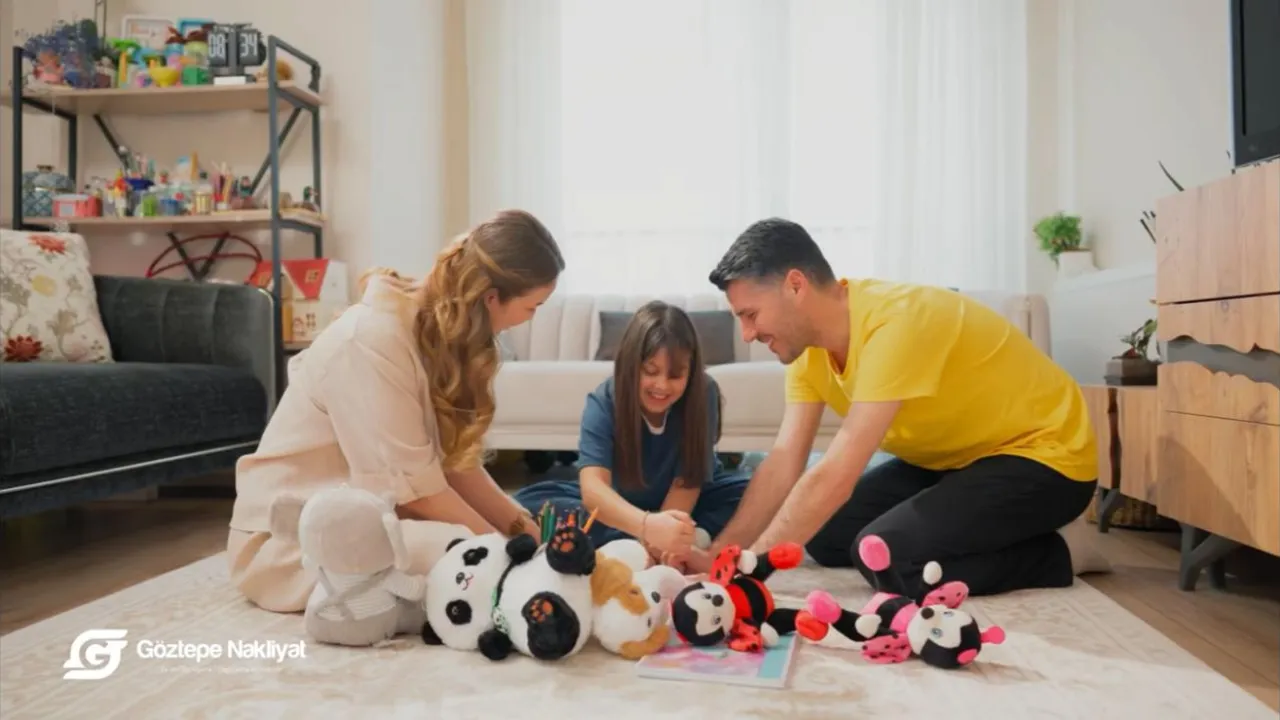 Reklam filminden bir kare: aile evde halıda oyuncaklarla oynuyor
